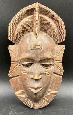 a wooden mask with a large head and a large face