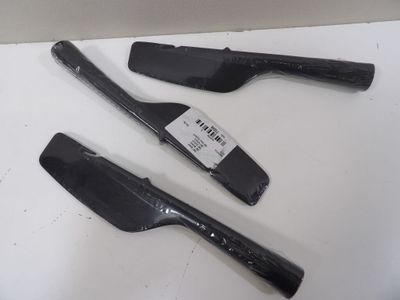 trois spatules noires posées sur une surface blanche