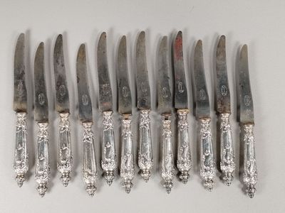 six knives are lined up in a row on a white surface