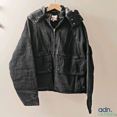 une photo d'une veste noire suspendue à un cintre