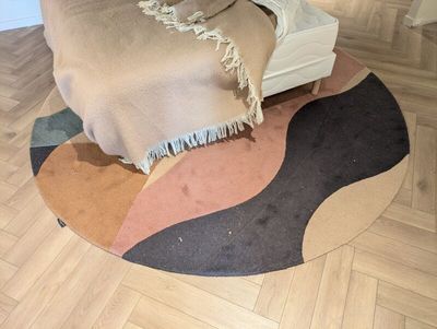 un tapis rond posé à même le sol, recouvert d'une couverture