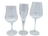 three empty wine glasses sitting next to each other on a white surface