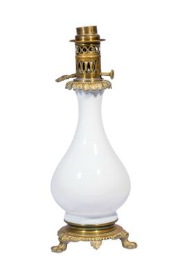 un vase blanc surmonté d'un couvercle doré, posé sur un socle