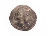une vieille pièce de monnaie sur laquelle figure un visage, sur un fond blanc