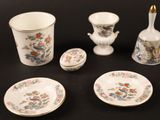quatre pièces de vaisselle sur une table, avec un vase, un bol et une assiette