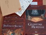 several books on a wooden table with a brown envelope and a brown book