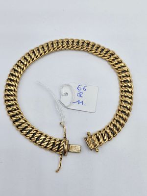un bracelet à chaîne en or avec un fermoir sur fond blanc