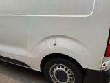 the rear end of a white van parked in a parking lot