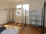 an image of a room with a lot of clothes on a rack