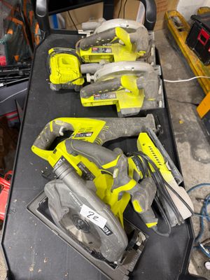 two corded circular saws and two circular circular saws on a workbench
