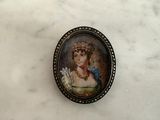 a miniature picture of a woman in a dress on a table