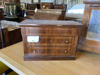 une commode en bois posée sur une table dans un magasin