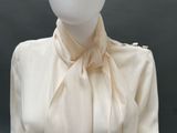 a mannequin wearing a white shirt with a bow on it