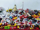 un tas de petites voitures par terre, près d'un mur