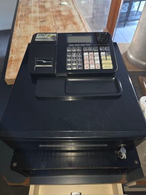 une caisse enregistreuse posée sur un comptoir en bois