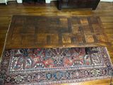 a rug on the floor next to a wooden table