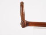 une image montrant un gros plan d'un objet en bois posé sur une surface blanche