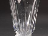 un vase en verre transparent posé sur une table, sur fond noir