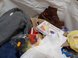 a pile of clothing and shoes on a bed
