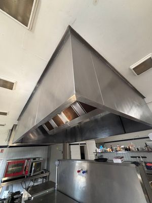 a large stainless steel hood in the middle of a kitchen