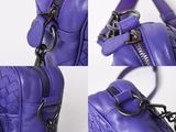 the purple purse has a zipper on the front and a chain on the back