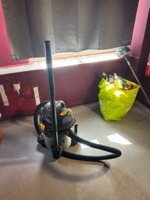 un aspirateur posé par terre près d'une fenêtre