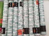 Plusieurs rouleaux de tissu sont alignés les uns à côté des autres sur une table