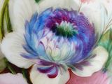 a close up of a vase with flowers painted on it