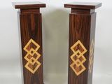 pair of wooden pedestals with gold and black designs on them