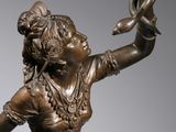 bronze statue of a woman with a bird in her hand