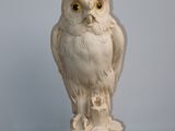 une statue représentant un hibou perché sur une table en bois