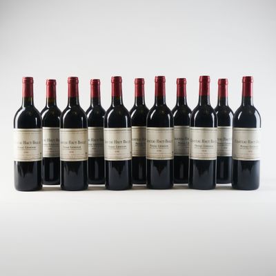 six bouteilles de vin rouge alignées sur une surface blanche