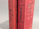 deux livres rouges posés l'un sur l'autre sur une surface blanche