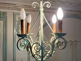 a picture of a chandelier with three candles hanging from it
