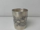 une tasse en argent antique avec un motif floral sur le bord