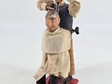 a figurine of a man getting his hair cut by a barber
