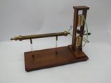 a wooden clock with a pendulum on a stand
