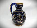 a blue and gold vase on a white surface