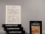 Plusieurs livres sont empilés les uns sur les autres devant un fond gris.