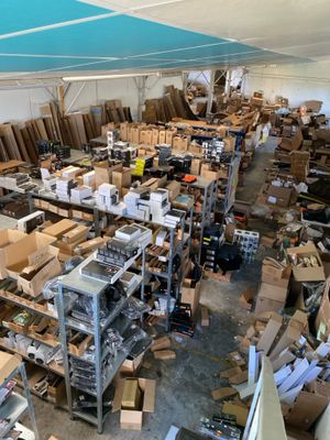 une grande pièce remplie de cartons, empilés les uns sur les autres sur des étagères