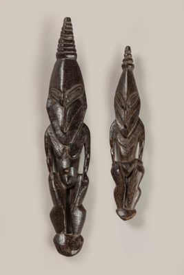 deux sculptures sur bois représentant un homme et une femme sur fond blanc