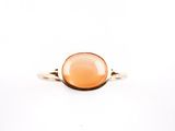Gros plan sur une bague contenant une pierre orange