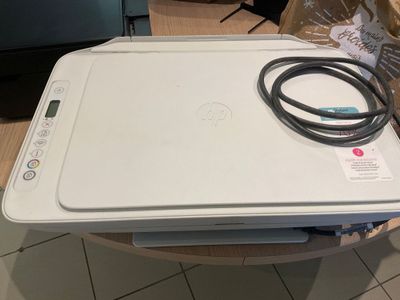 une imprimante blanche posée sur une table en bois