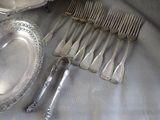 a lot of silver spoons and forks on a table
