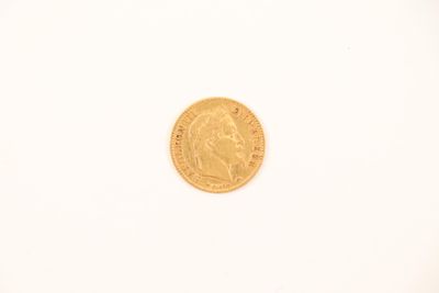 a close up of a gold coin on a white surface