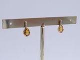 a pair of earrings that are on a metal stand