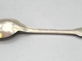 an old spoon with a spoon handle sitting on top of a table