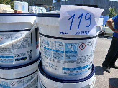 Plusieurs seaux de peinture sont empilés les uns sur les autres dans un parking