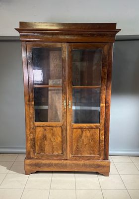 une vieille armoire en bois avec des portes vitrées dans une pièce