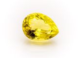 a close up of a yellow sapphire stone on a white surface
